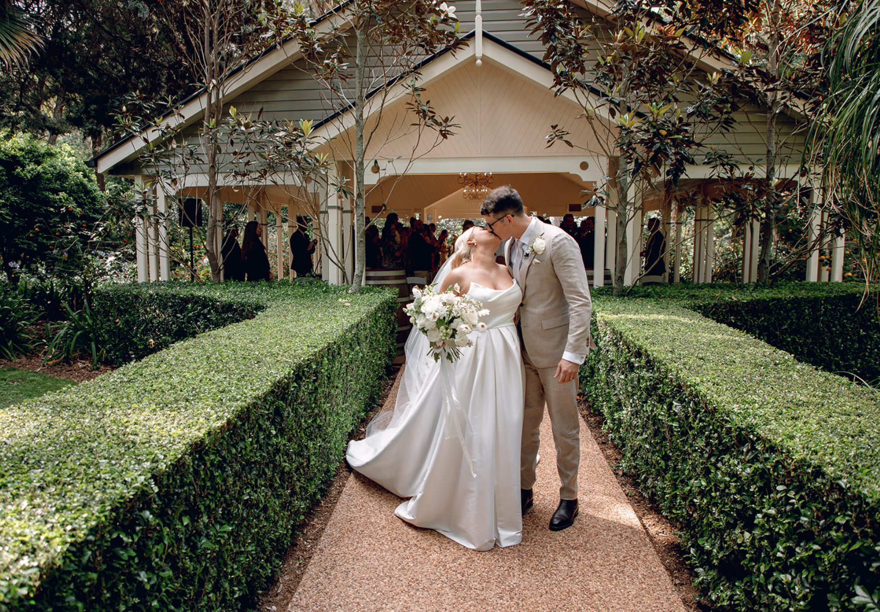 bride and groom kissing in front of a chapel