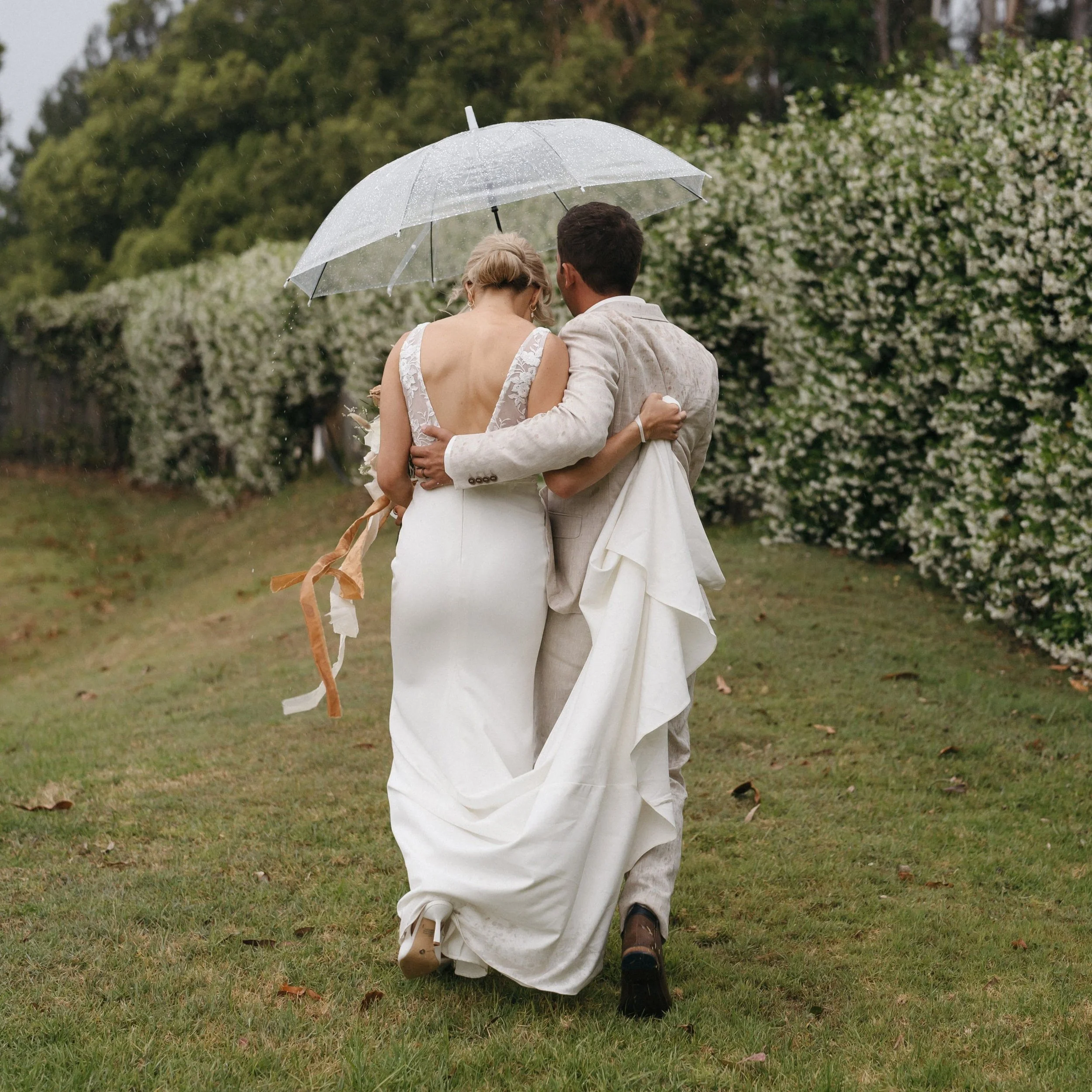 newlyweds walking under an umbrella