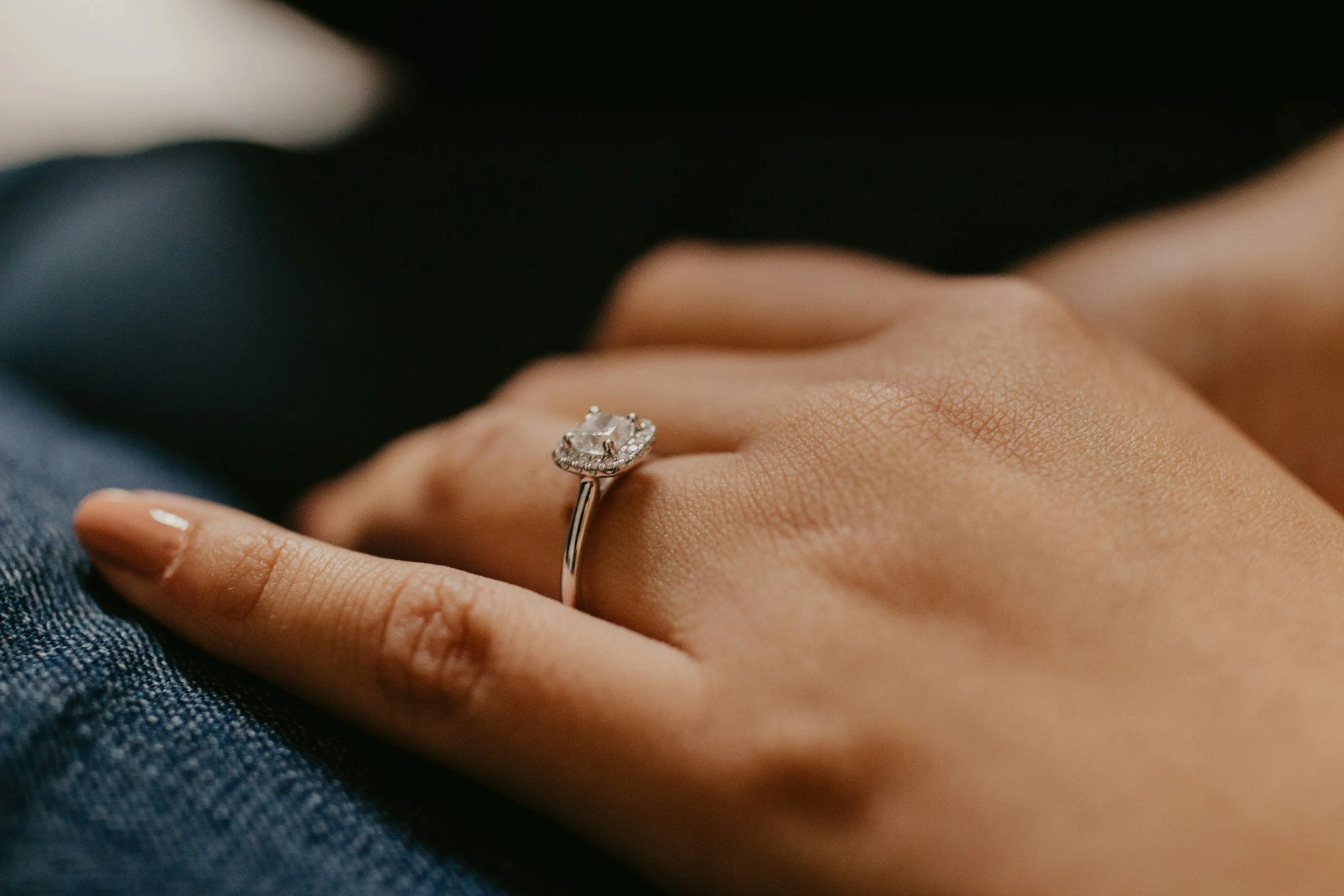 engagement ring on a woman's finger, her hand is on a man's suit sleeve