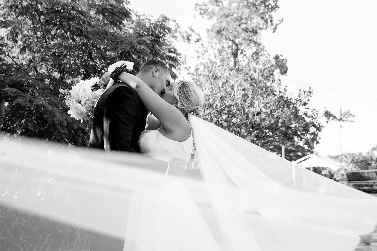 newlyweds kiss under the bride's veil