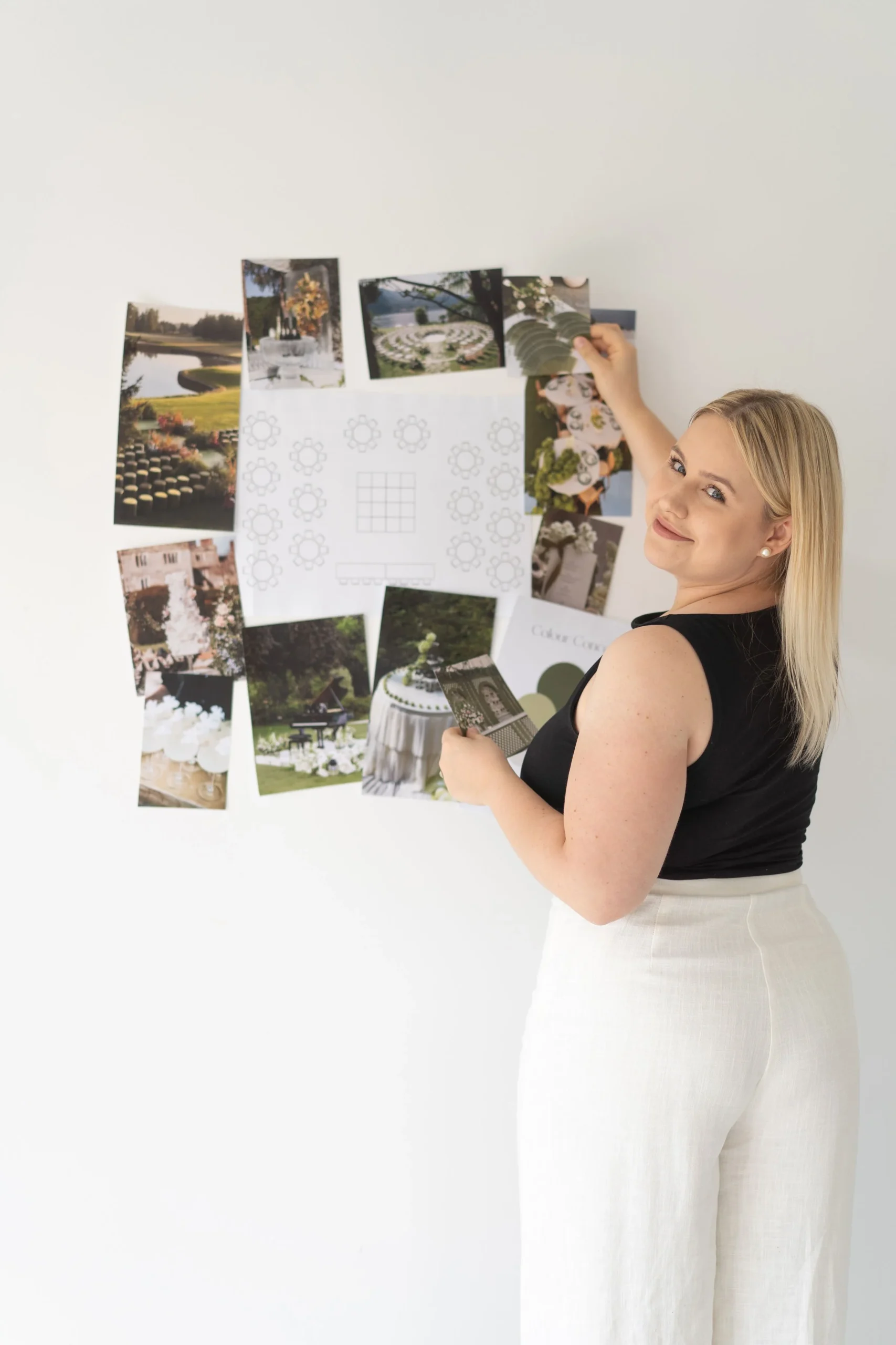 Wedding planner brainstorming wedding design, arranging photos and sketches on a white wall.