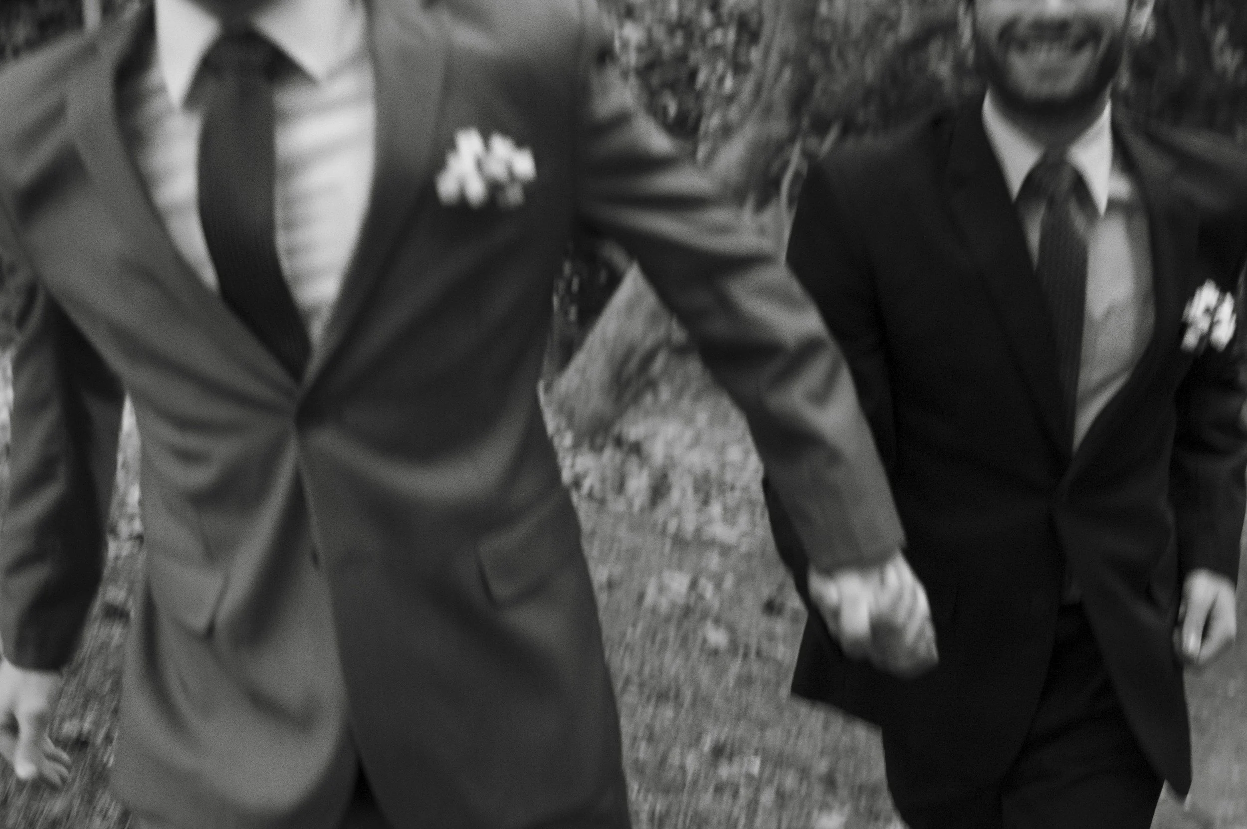 close up of grooms running hand in hand